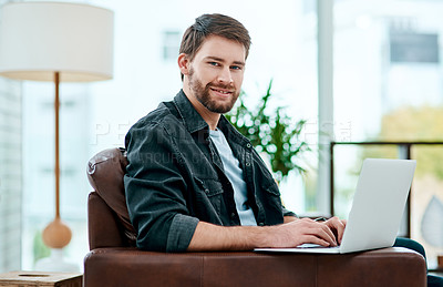 Buy stock photo Shot of a young man using a laptop on the sofa at home