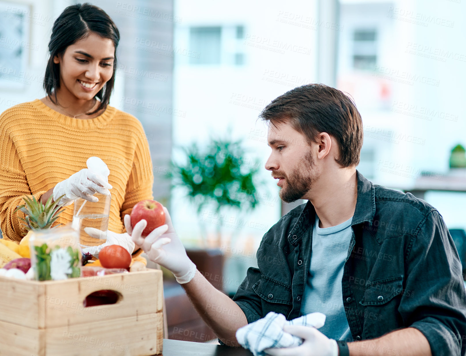 Buy stock photo Grocery, fruit and sanitizer with couple in house for pesticide cleaning, shopping and supermarket deal. Nutrition, food and wellness with man and woman at home for consumer, vegetables and health