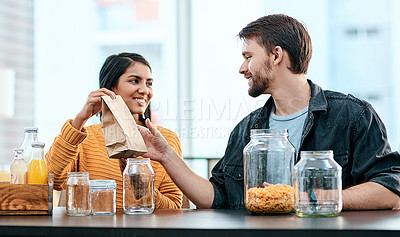 Buy stock photo Cereal, glass and sorting with interracial couple in kitchen of home together to organize food or groceries. Giving, jar or paper bag with man and woman in apartment for diet, health or wellness