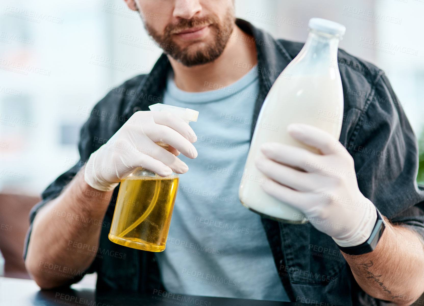 Buy stock photo Shot of a young man disinfecting a bottle pf milk at home