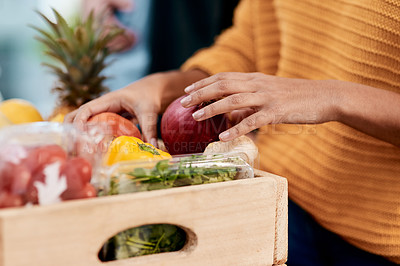 Buy stock photo Cropped shot of a woman unpacking her groceries in the kitchen at home