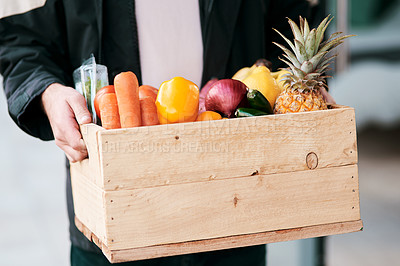 Buy stock photo Cropped shot of a man delivering fresh fruit and vegetables to a place of residence