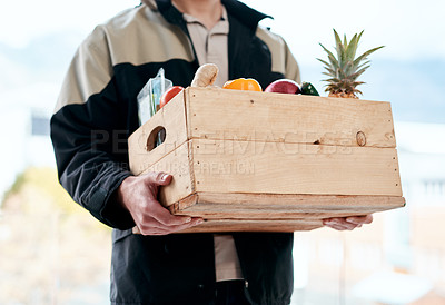 Buy stock photo Cropped shot of a man delivering fresh fruit and vegetables to a place of residence