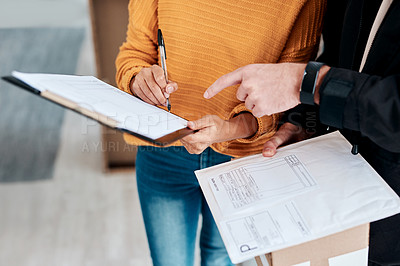 Buy stock photo Cropped shot of a woman signing for a delivery received at home