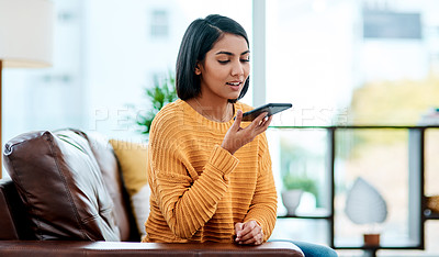 Buy stock photo Shot of a young woman using a smartphone on the sofa at home