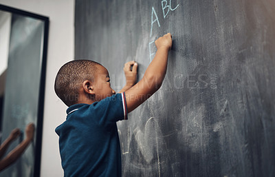 Buy stock photo Cropped shot of a young boy writing on a blackboard at home