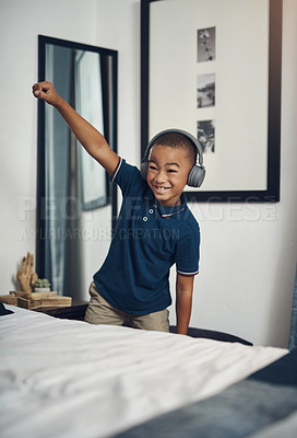 Buy stock photo Cropped shot of a young boy listening to music through headphones at home