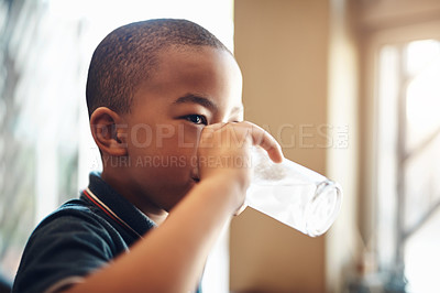 Buy stock photo Drinking, water and African boy child in home with fresh hydration, nutrition and healthy development. Thinking, wellness and thirsty kid in kitchen with clean beverage in glass on weekend morning