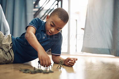 Buy stock photo Shot of a young boy playing with toy soldiers at home
