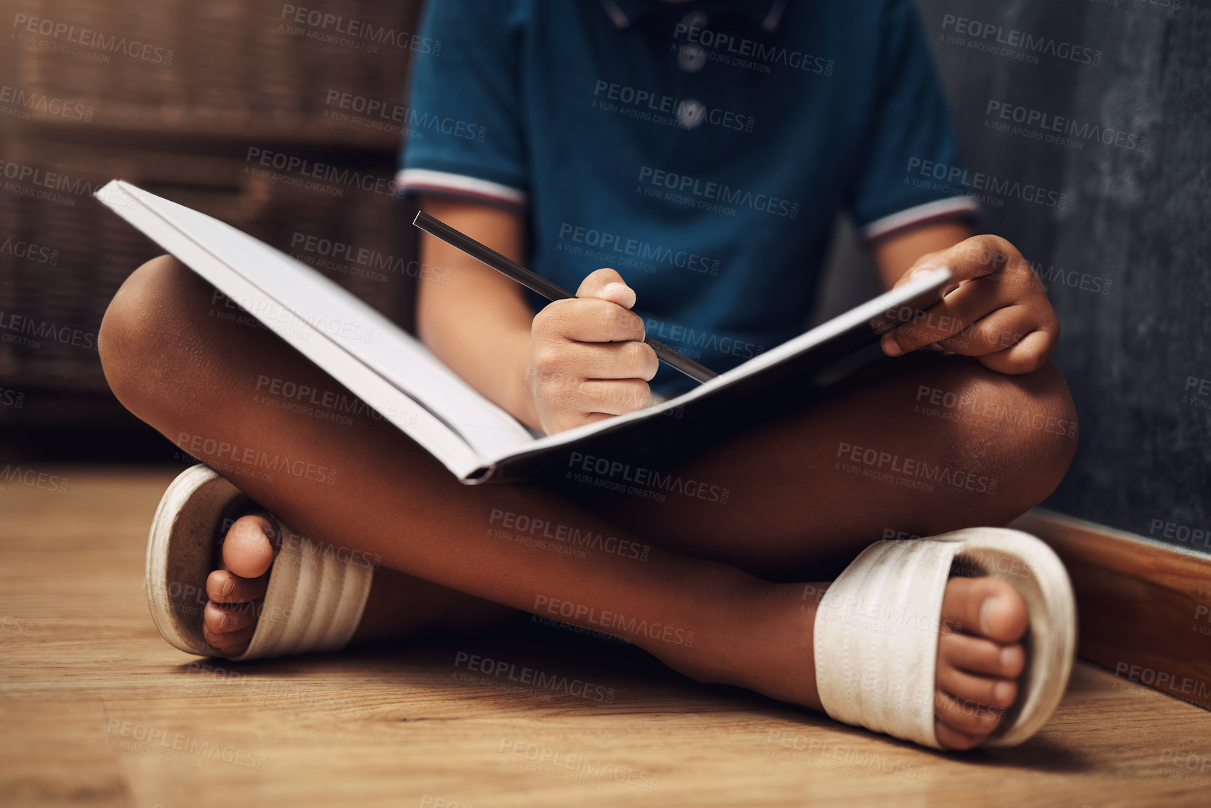 Buy stock photo Cropped shot of an unrecognizable boy writing in a book at home