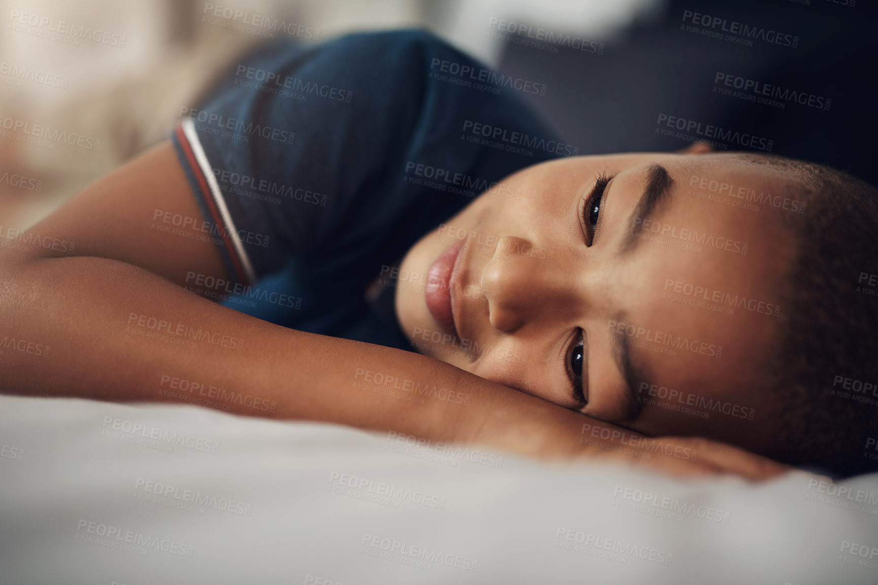 Buy stock photo Shot of an adorable little boy lying on his bed at home