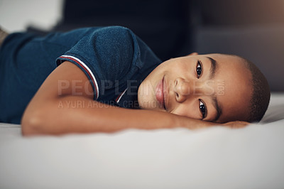 Buy stock photo Shot of an adorable little boy lying on his bed at home