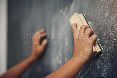 Buy stock photo Cropped shot of an unrecognizable boy using the duster to clean a blackboard