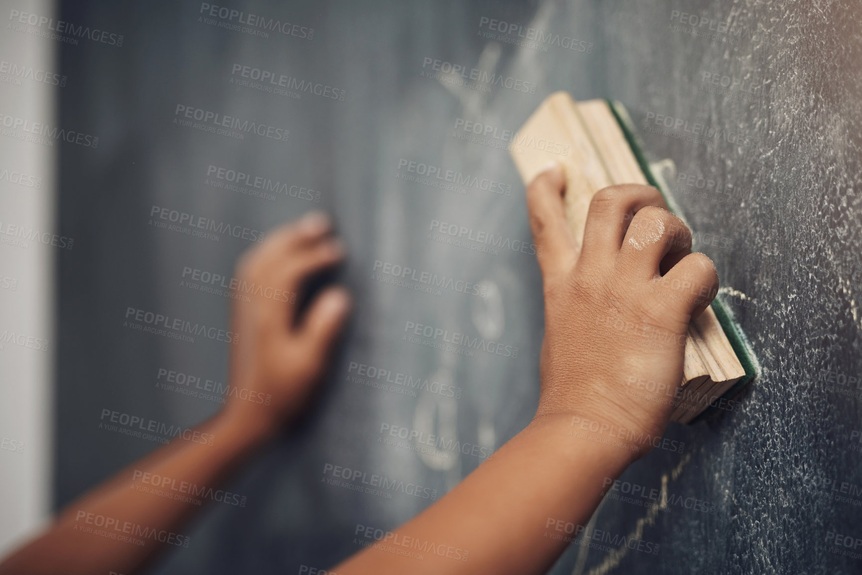Buy stock photo Cropped shot of an unrecognizable boy using the duster to clean a blackboard