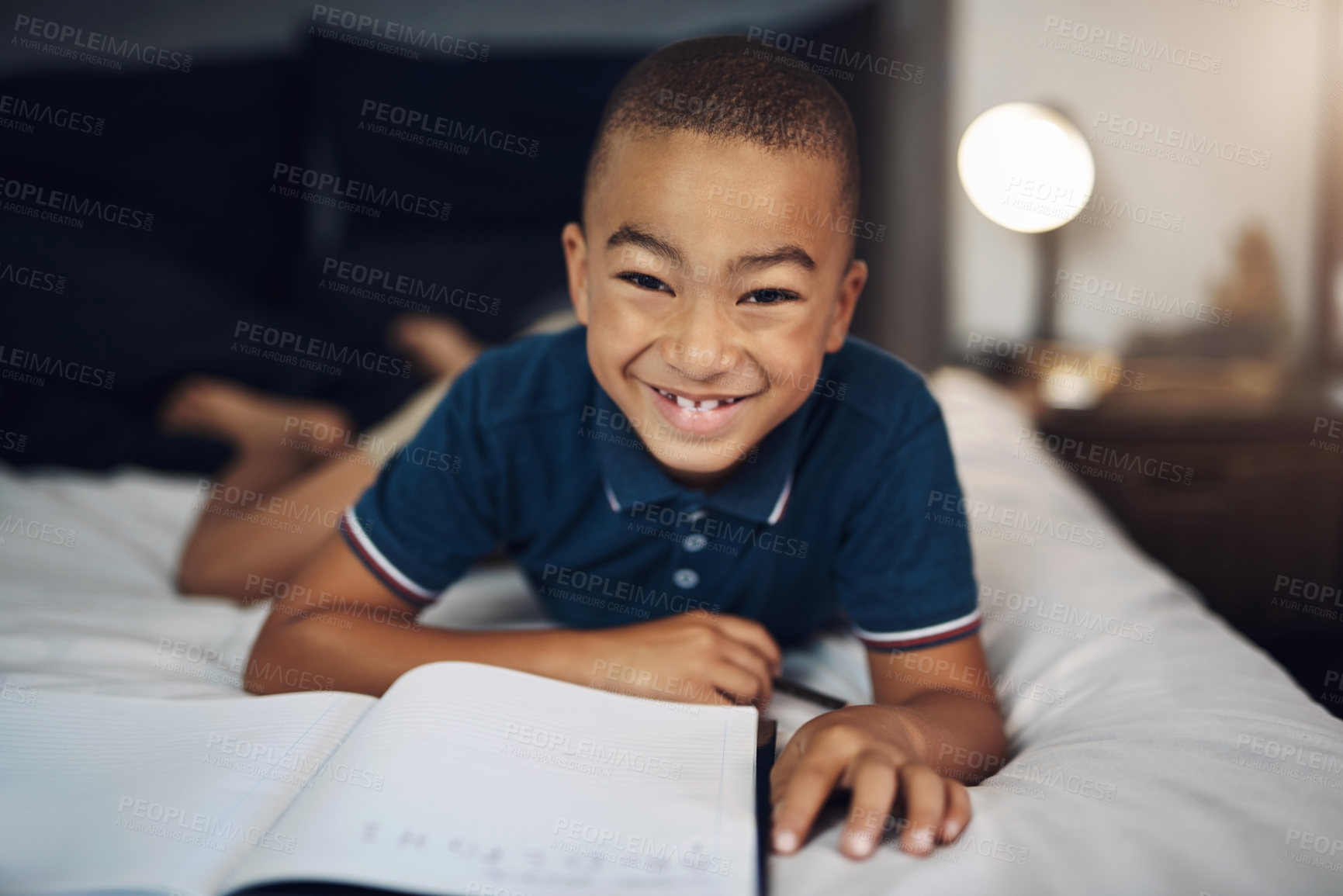 Buy stock photo Happy boy, portrait and lying with book in bed for education, learning or childhood development at home. Young, male person or teenager in bedroom with smile for homework or fun activity at house