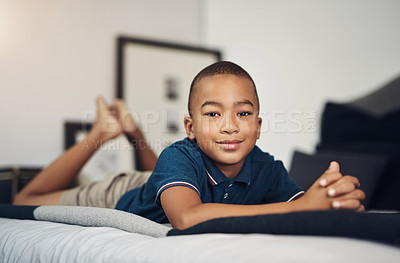 Buy stock photo Shot of an adorable young boy lying on his bed