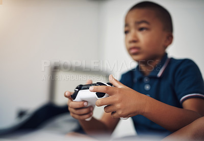 Buy stock photo Shot of a young boy playing video games at home
