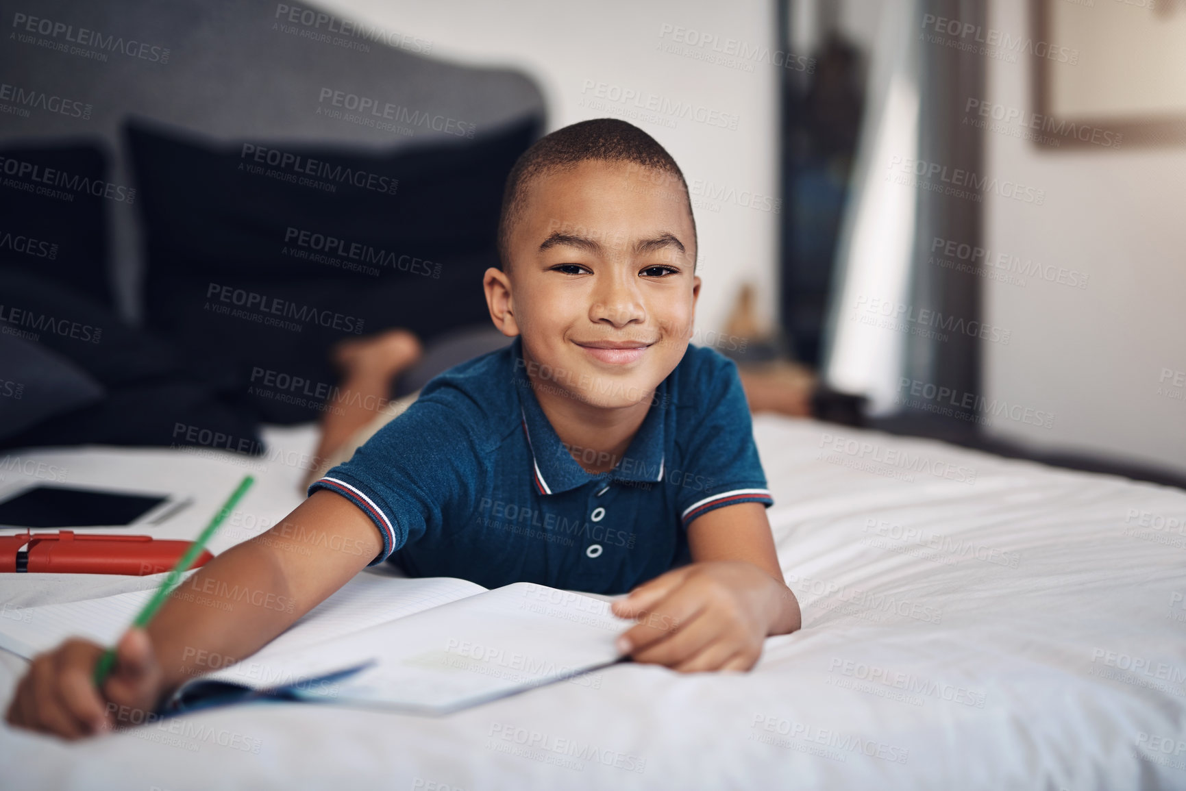 Buy stock photo Shot of a young boy using colouring pencils while drawing at home