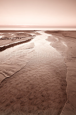 Buy stock photo A golden sunset over rippling low tide waters on the west coast of Jutland in Loekken, Denmark. Beautiful and magical empty beach at dusk. Clouds over the ocean and sea in the evening with copy space