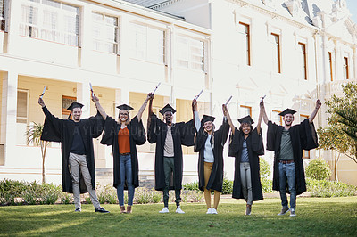 Buy stock photo Portrait of a group of students standing in a line with their arms raised on graduation day