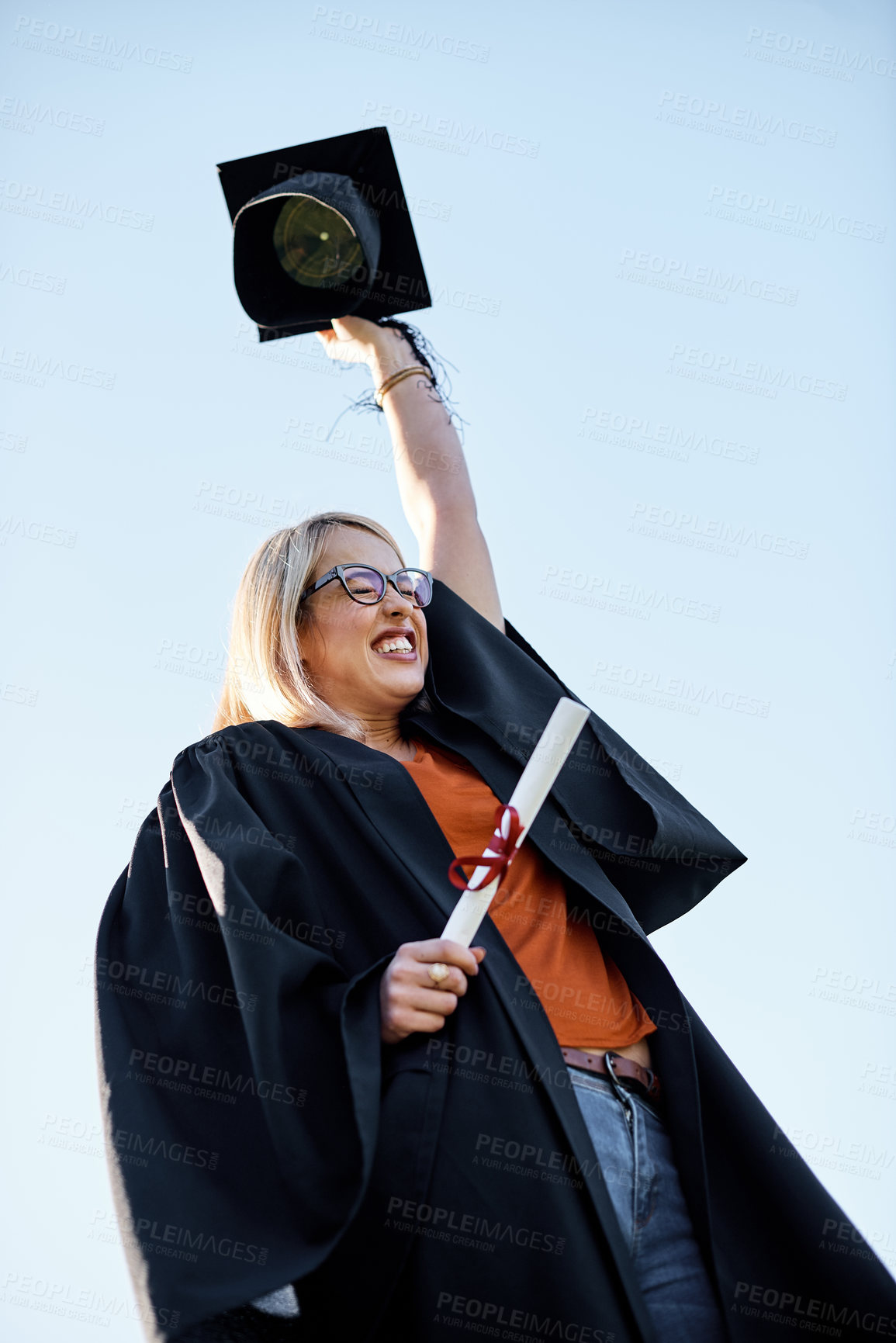 Buy stock photo Shot of a young student looking excited on graduation day