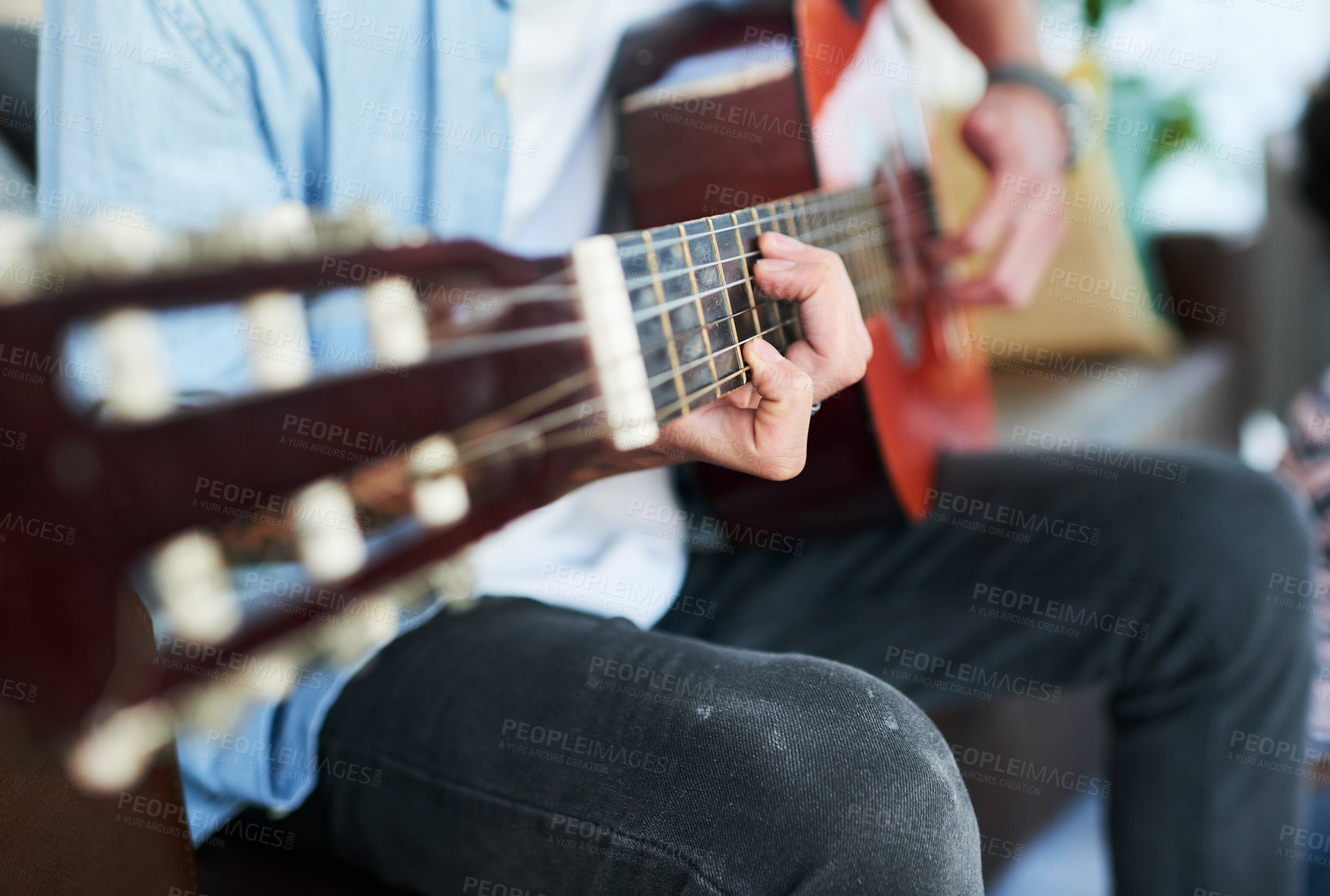 Buy stock photo Cropped shot of a man playing the guitar while sitting at home