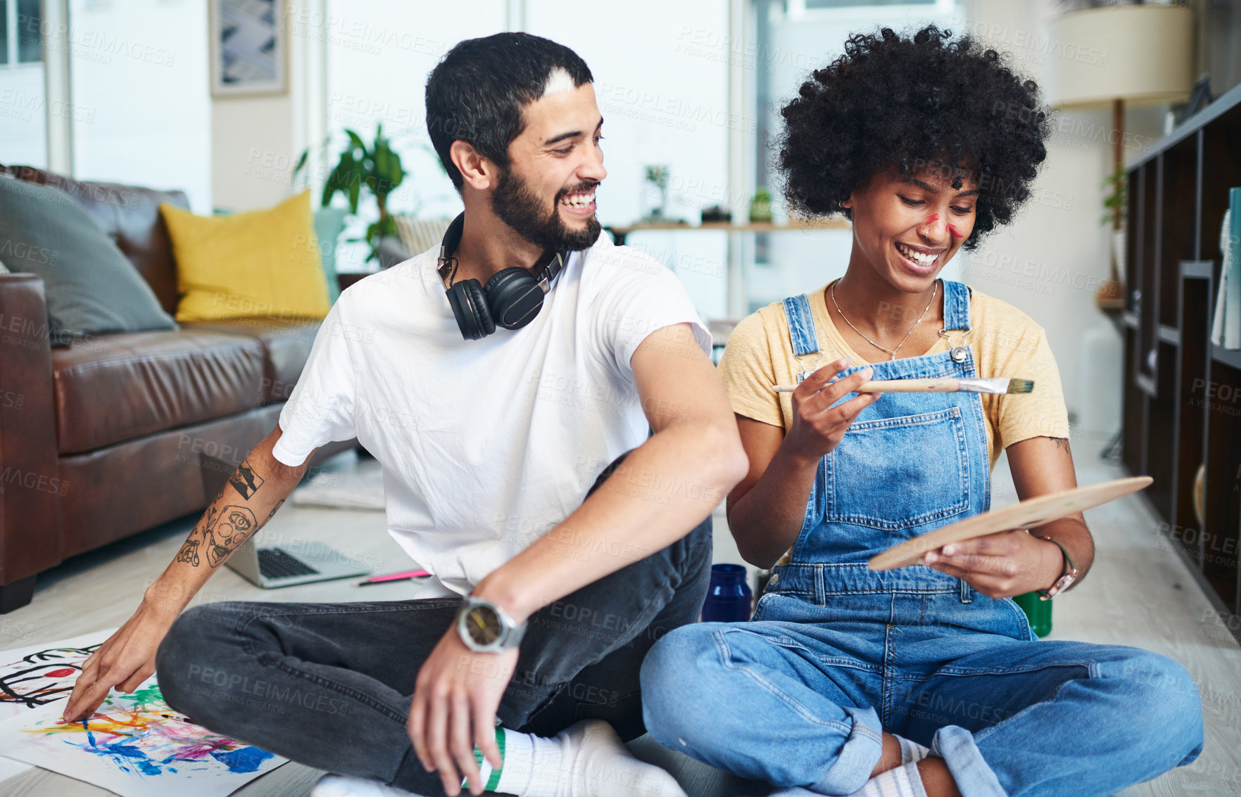 Buy stock photo Shot of a young couple enjoying themselves while painting at home