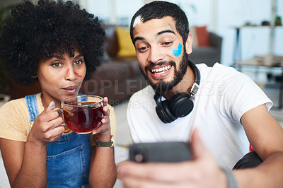 Buy stock photo Shot of a man holding up his cellphone while sitting at home with his girlfriend