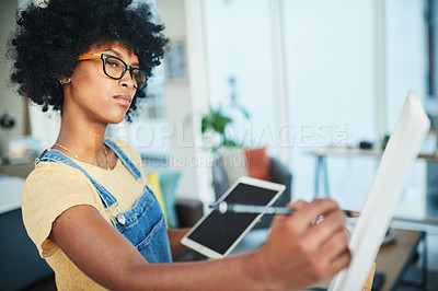 Buy stock photo Shot of a young artist holding a digital tablet while painting on a canvas at home