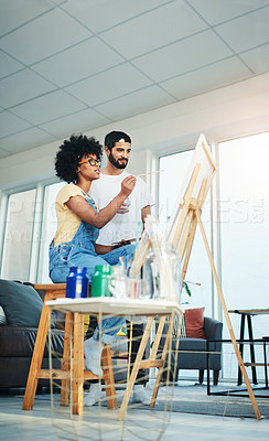 Buy stock photo Shot of a man watching his artistic girlfriend paint on a canvas