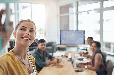 Buy stock photo Shot of a young businesswoman using a glass wall during a presentation to her colleagues in an office