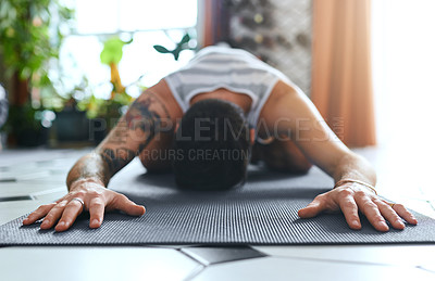 Buy stock photo Shot of a young man going through a yoga routine at home
