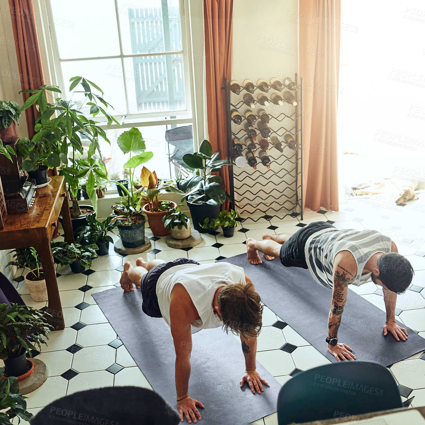 Buy stock photo Shot of two young men doing planks during a yoga routine at home