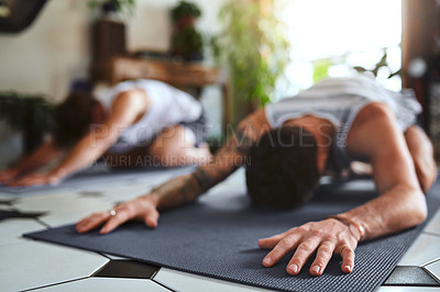 Buy stock photo Shot of two men going through a yoga routine at home