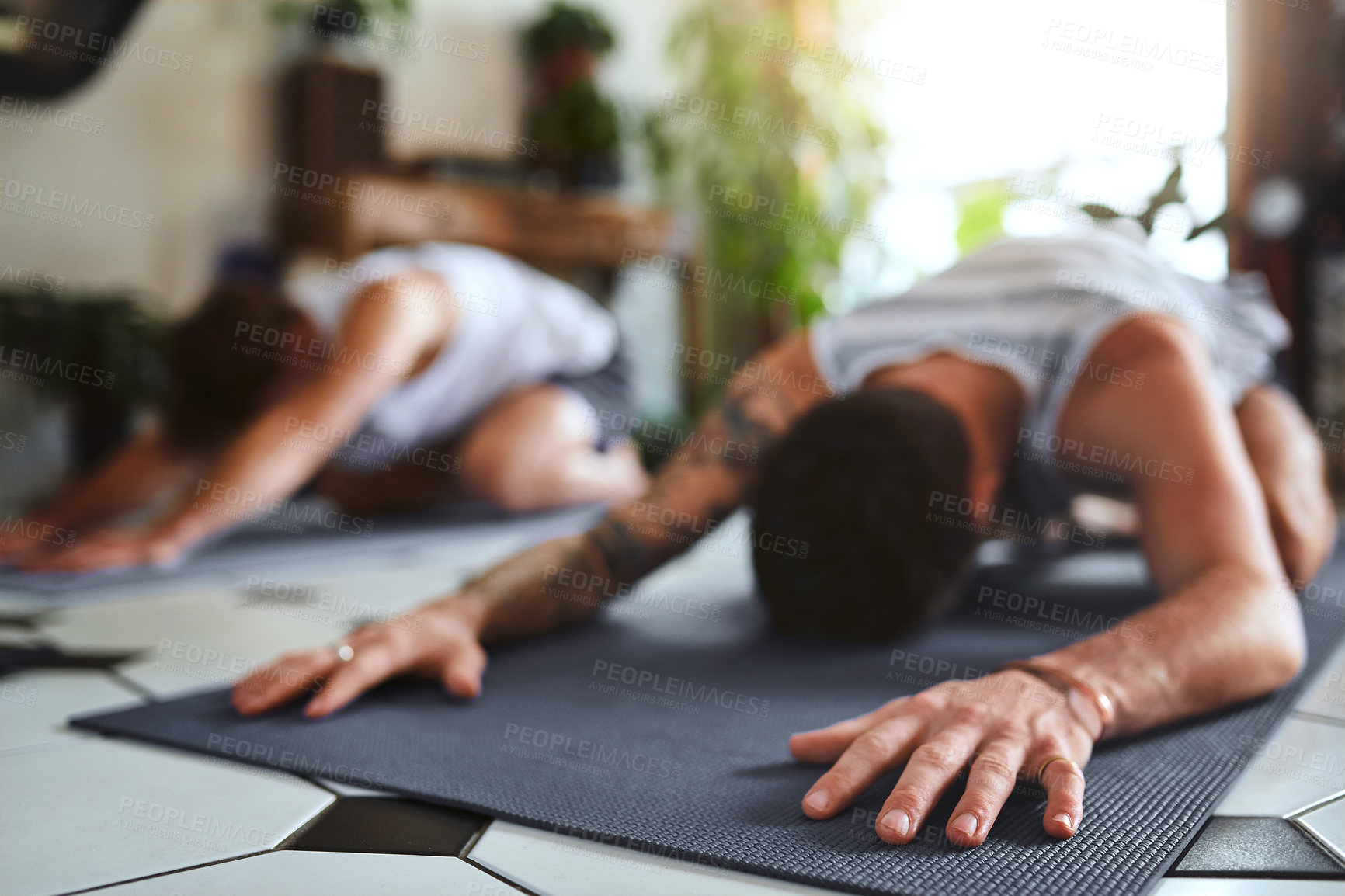 Buy stock photo Shot of two men going through a yoga routine at home