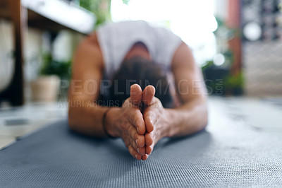 Buy stock photo Shot of a young man going through a yoga routine at home