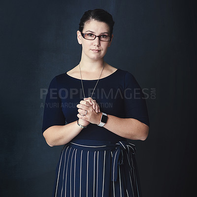 Buy stock photo Studio portrait of a corporate businesswoman posing against a dark background