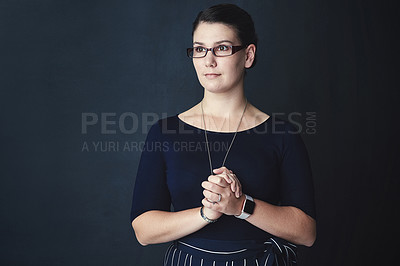 Buy stock photo Studio shot of a corporate businesswoman looking thoughtful against a dark background