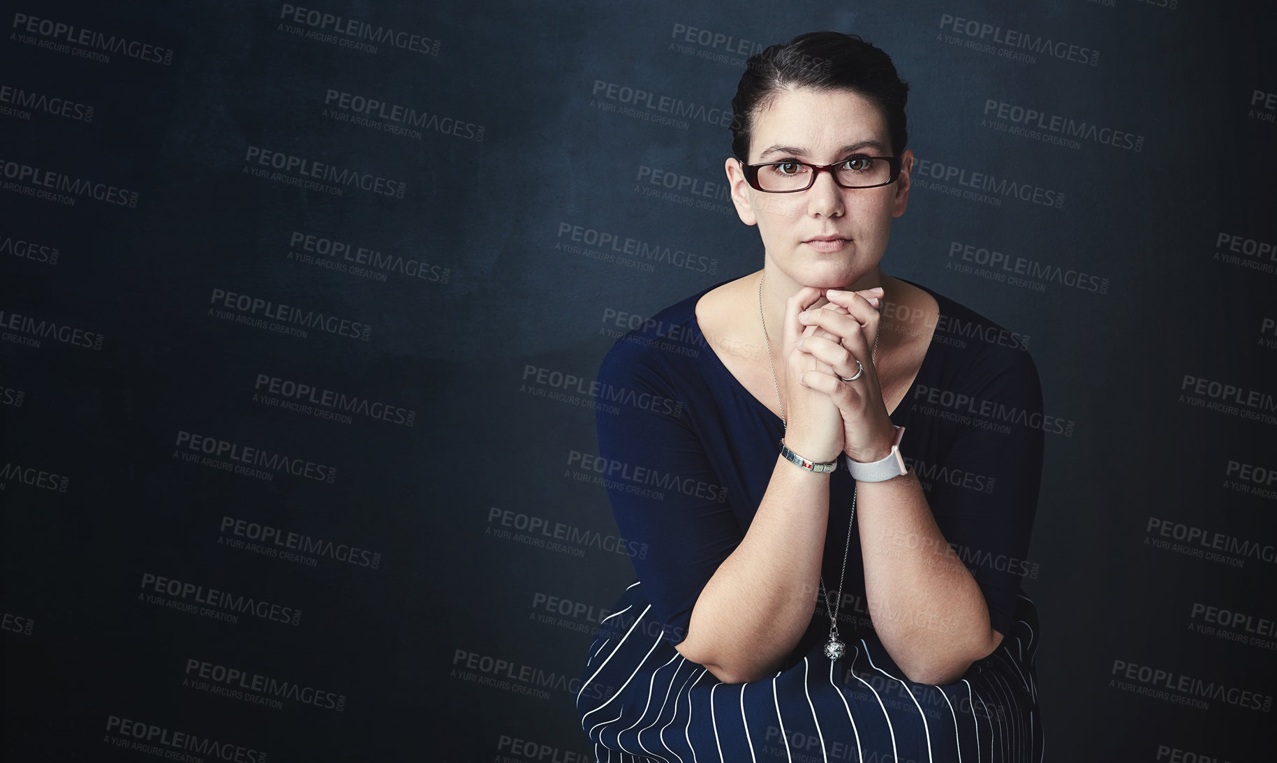 Buy stock photo Studio portrait of a corporate businesswoman posing against a dark background