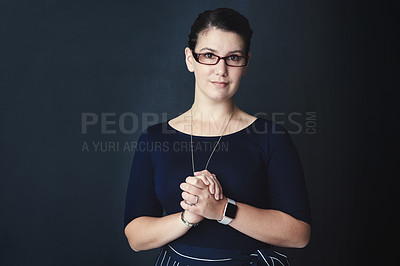 Buy stock photo Studio portrait of a corporate businesswoman posing against a dark background