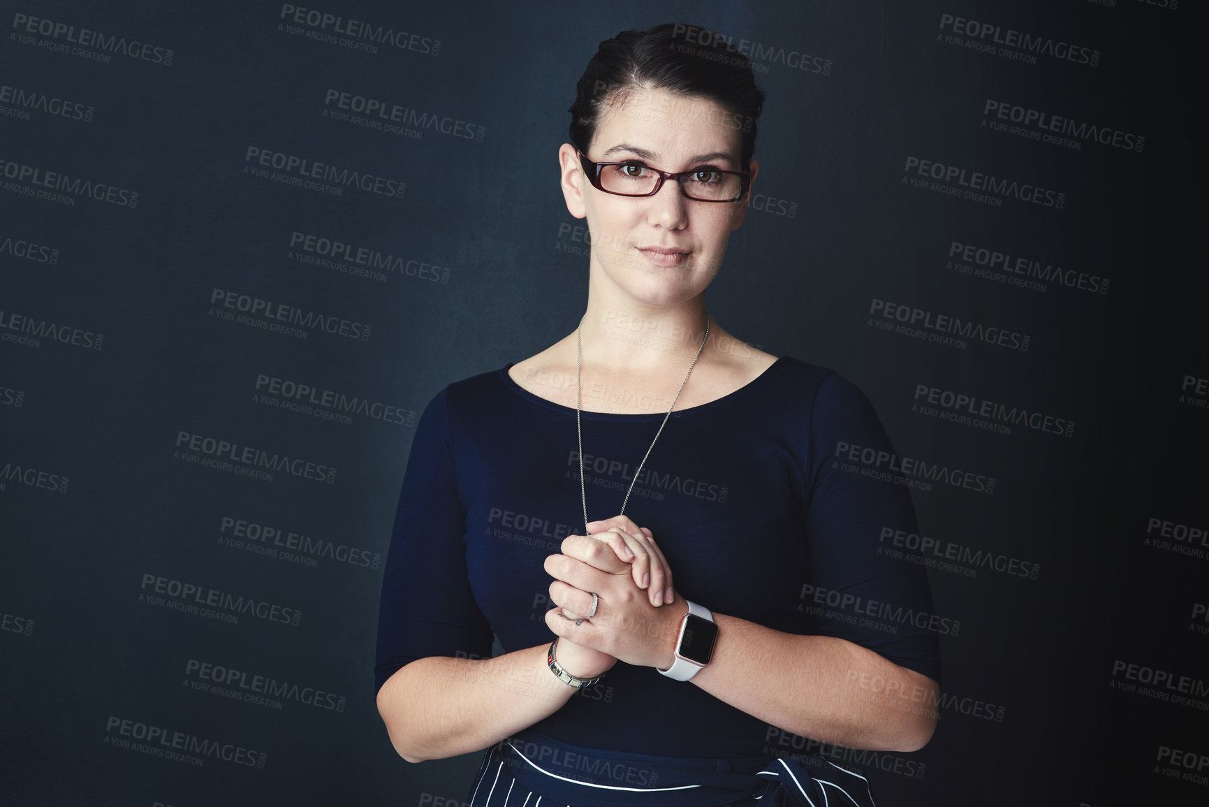 Buy stock photo Studio portrait of a corporate businesswoman posing against a dark background