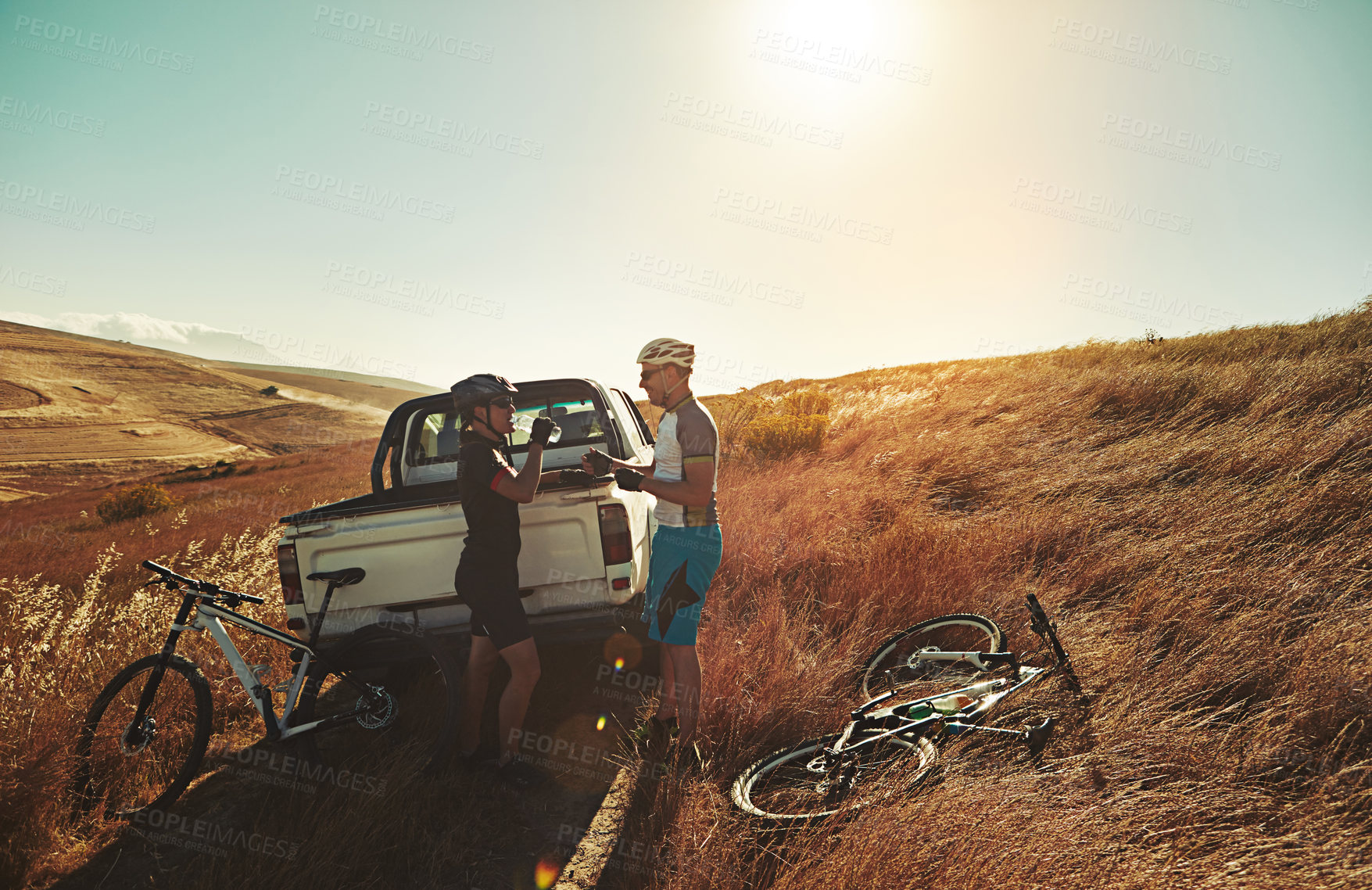 Buy stock photo Shot of a pair of adventurous mountain bikers getting ready to explore a new trail together