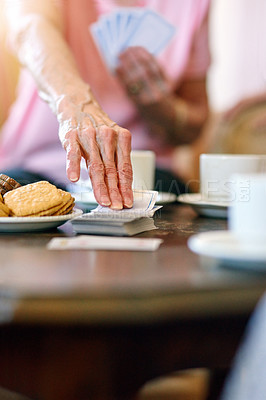 Buy stock photo Shot of an unidentifiable senior woman picking up a card during a game with her friends in a retirement home