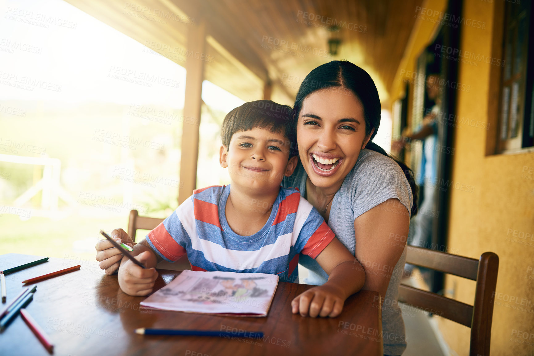 Buy stock photo Cropped shot of a young beautiful mother colouring in pictures with her adorable son at home