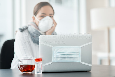 Buy stock photo Shot of a masked young businesswoman working with hand sanitiser, a laptop and herbal tea at her desk