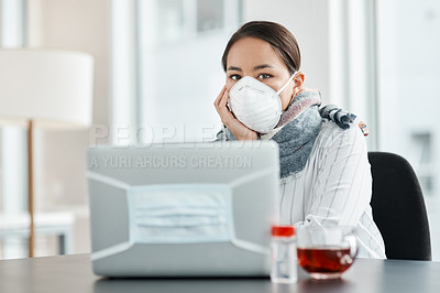Buy stock photo Shot of a masked young businesswoman working with hand sanitiser, a laptop and herbal tea at her desk