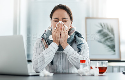 Buy stock photo Shot of a young businesswoman blowing her nose at her desk in a modern office