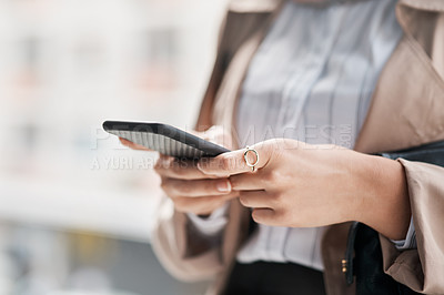 Buy stock photo Cropped shot of an unrecognizable woman using her cellphone against a city background