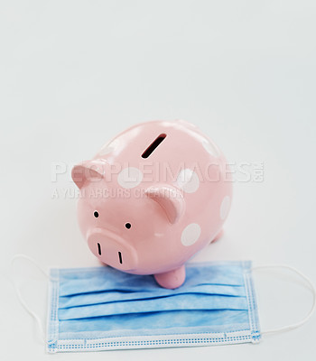 Buy stock photo Shot of a piggybank and a face mask against a white background