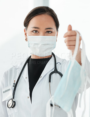 Buy stock photo Cropped shot of a medical practitioner holding up a face mask
